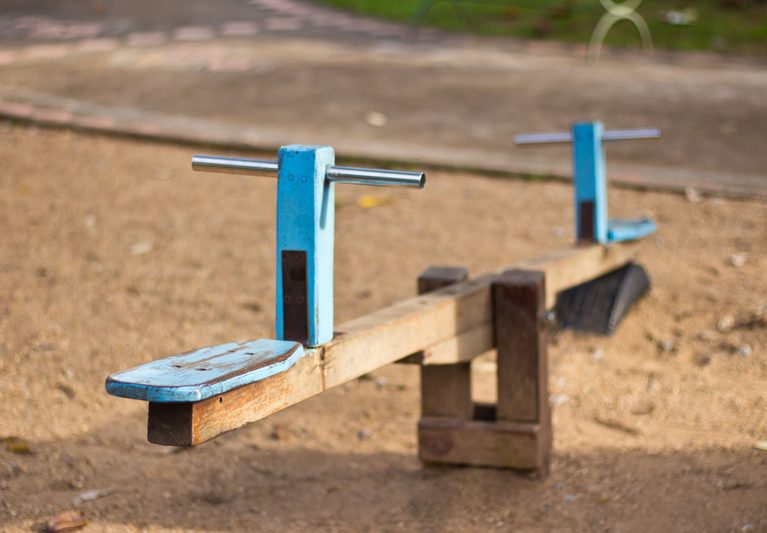 Old wooden see saw at the playground